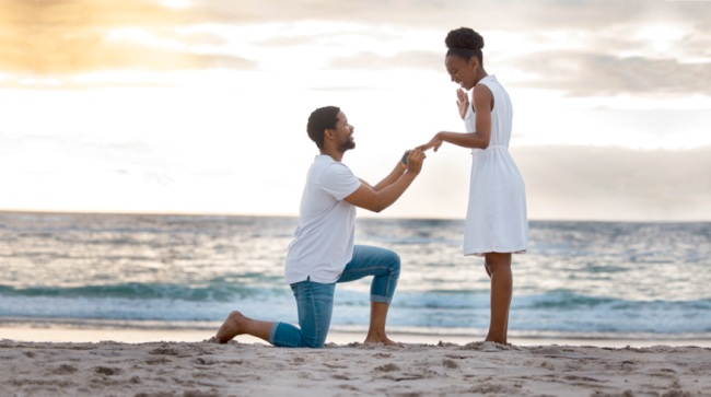 Man engaging to his girlfriend on the beach.