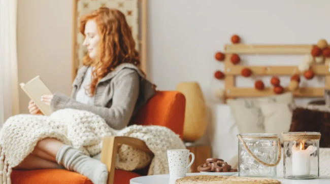 Women reading a book in her living room.