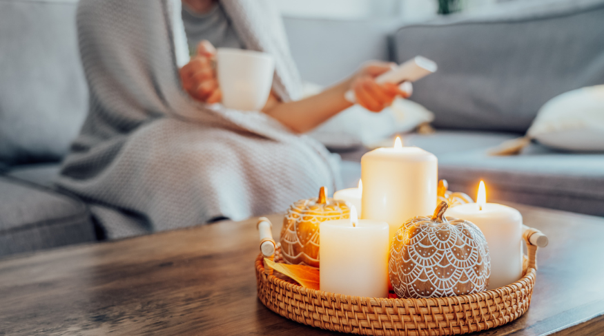 Girl sitting on her couch enjoying a cozy fall day inside.